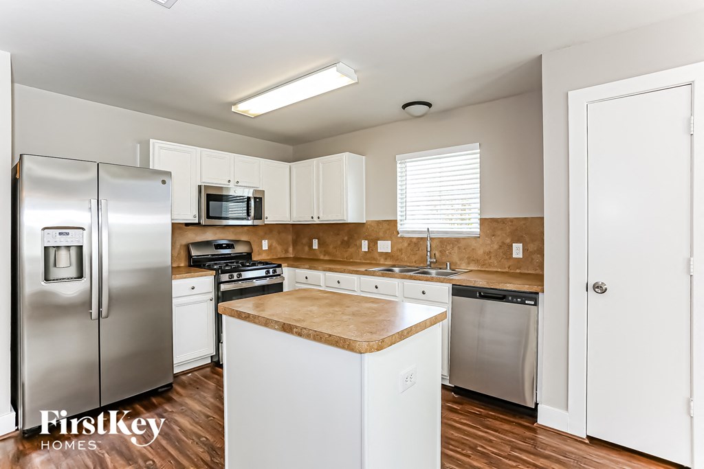 a kitchen with white cabinets and stainless steel appliances