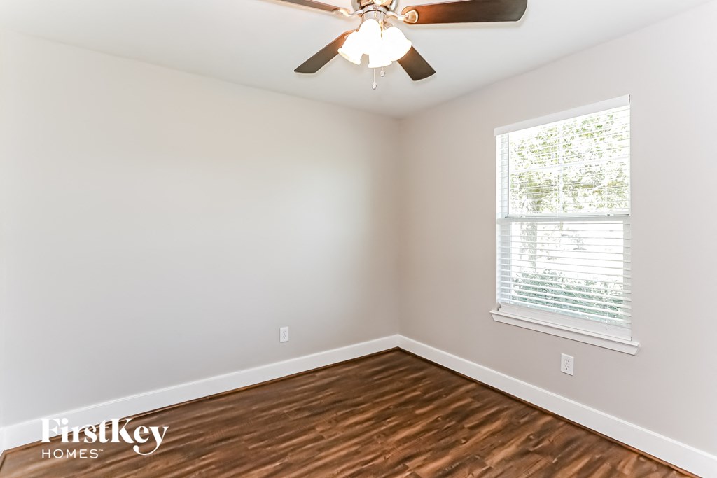 a bedroom with hardwood flooring and a ceiling fan