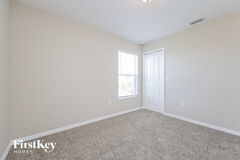 a bedroom with a carpeted floor and a white door