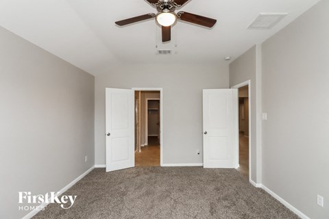 a bedroom with carpet and a ceiling fan