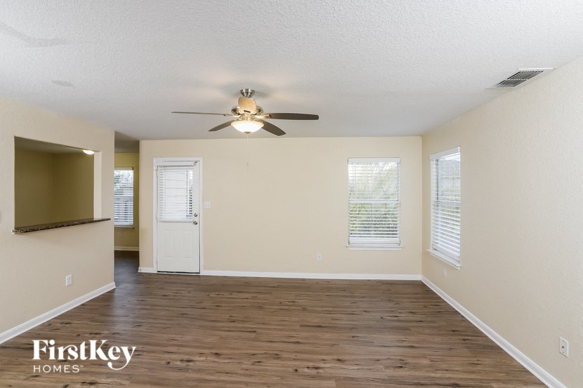 A spacious room with a ceiling fan and wooden flooring.
