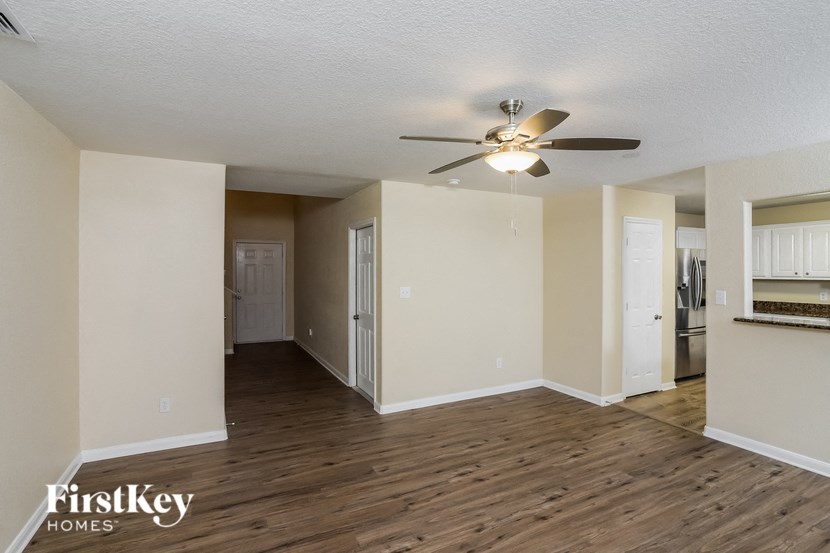 A spacious room with a ceiling fan and wooden flooring.