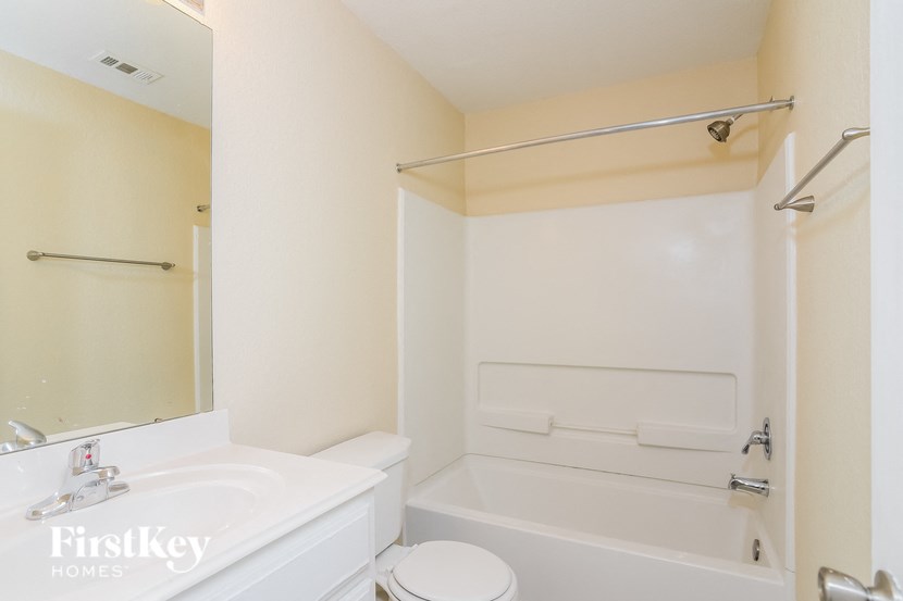 A white bathroom with a toilet, sink, and bathtub.