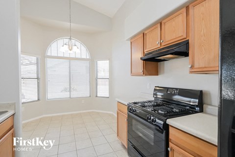 a kitchen with wood cabinets and black appliances and a window