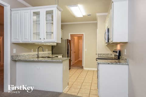 a kitchen with white cabinets and a sink and a counter