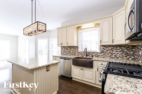A kitchen with a granite counter top and a stove top oven.