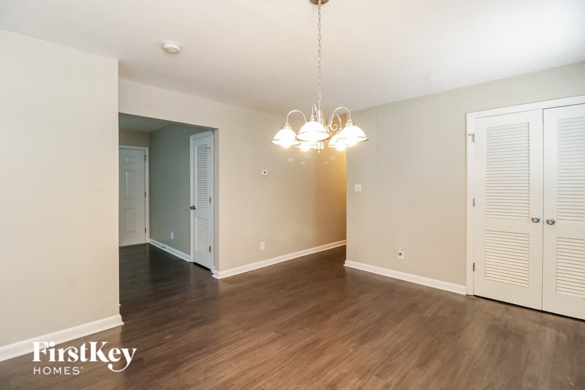 an empty living room with wood floors and white closets