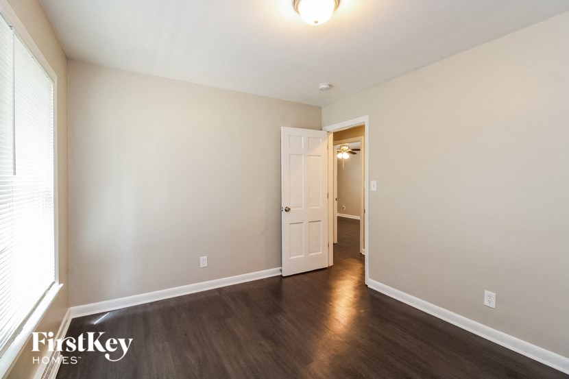 a living room with wood flooring and a door to a hallway