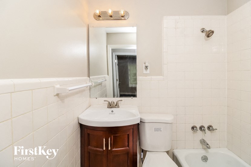 a bathroom with a sink toilet and a mirror