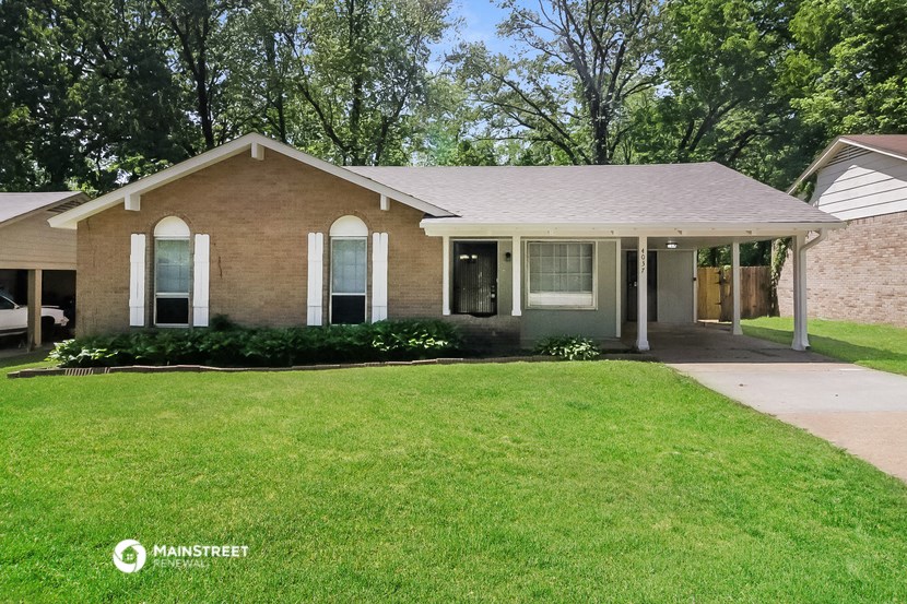a brick house with a lawn and a covered porch