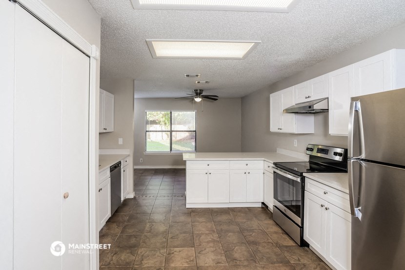 an empty kitchen with white cabinets and stainless steel appliances