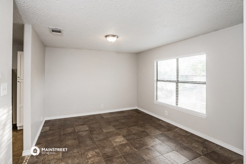 the spacious living room with a large window and tile flooring