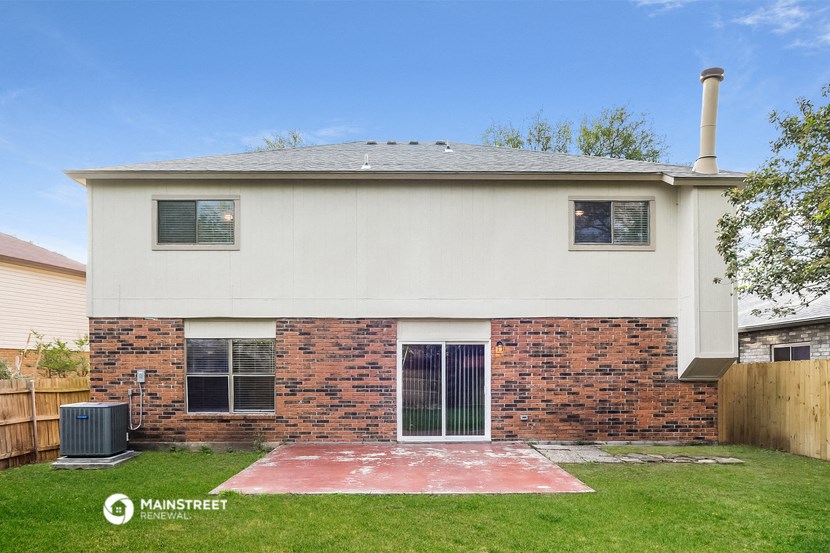 the front of a brick house with a yard and grass