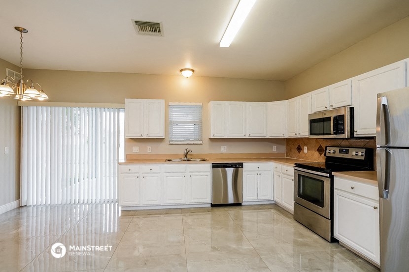 a kitchen with white cabinets and stainless steel appliances