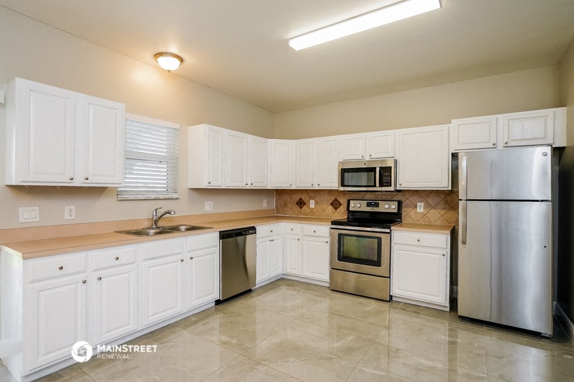 a kitchen with white cabinets and stainless steel appliances