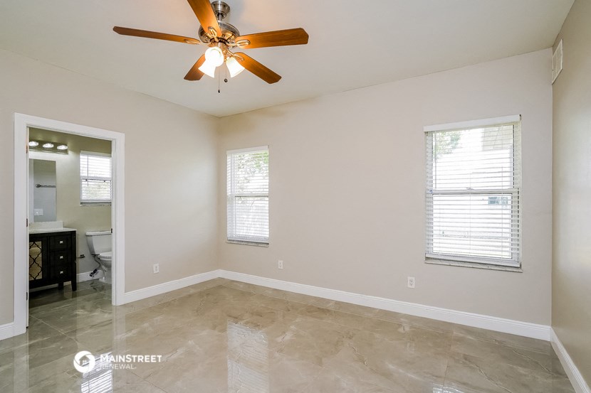 the spacious living room with ceiling fan and tiled floor