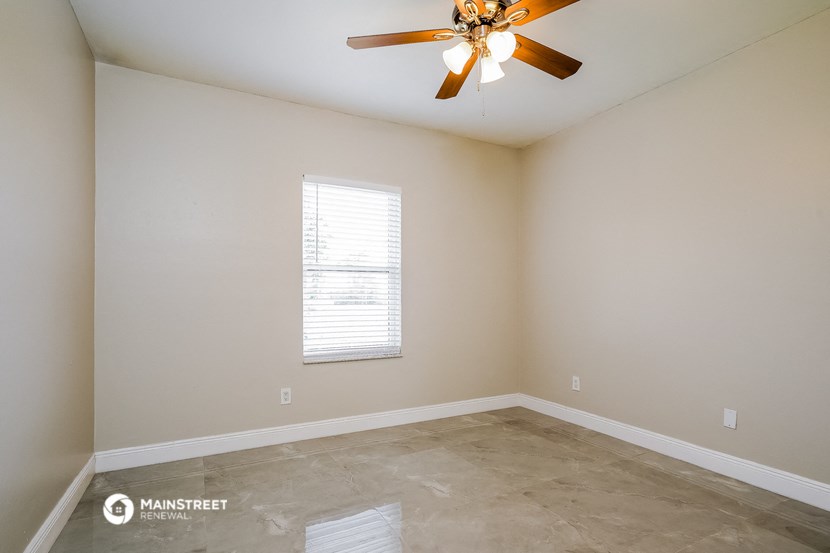 a empty room with a ceiling fan and a window