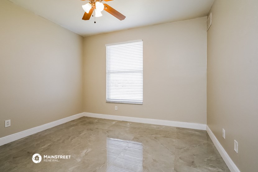 a empty room with a ceiling fan and a window