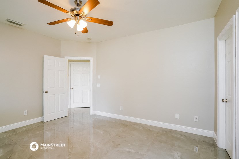 a empty living room with a ceiling fan