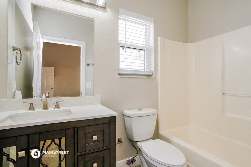a bathroom with a toilet sink and shower and a mirror