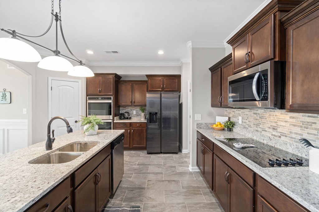 a kitchen with granite counter tops and wooden cabinets
