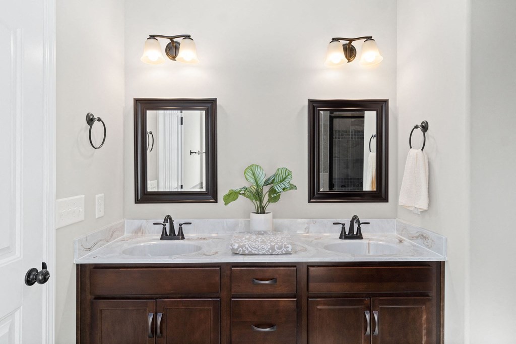 a bathroom with two sinks and two mirrors