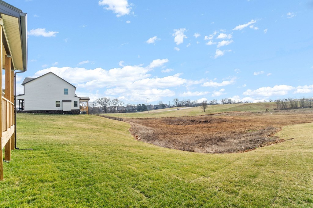 a view of a field with a house in the background