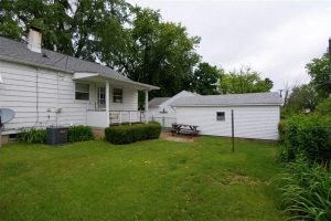 A white house with a grey roof and a white garage.