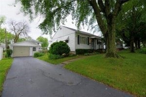 A white house with a driveway in front.