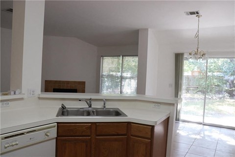 an empty kitchen with a sink and a window