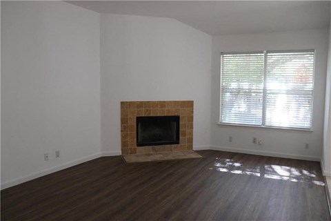a living room with a fireplace and wooden floors