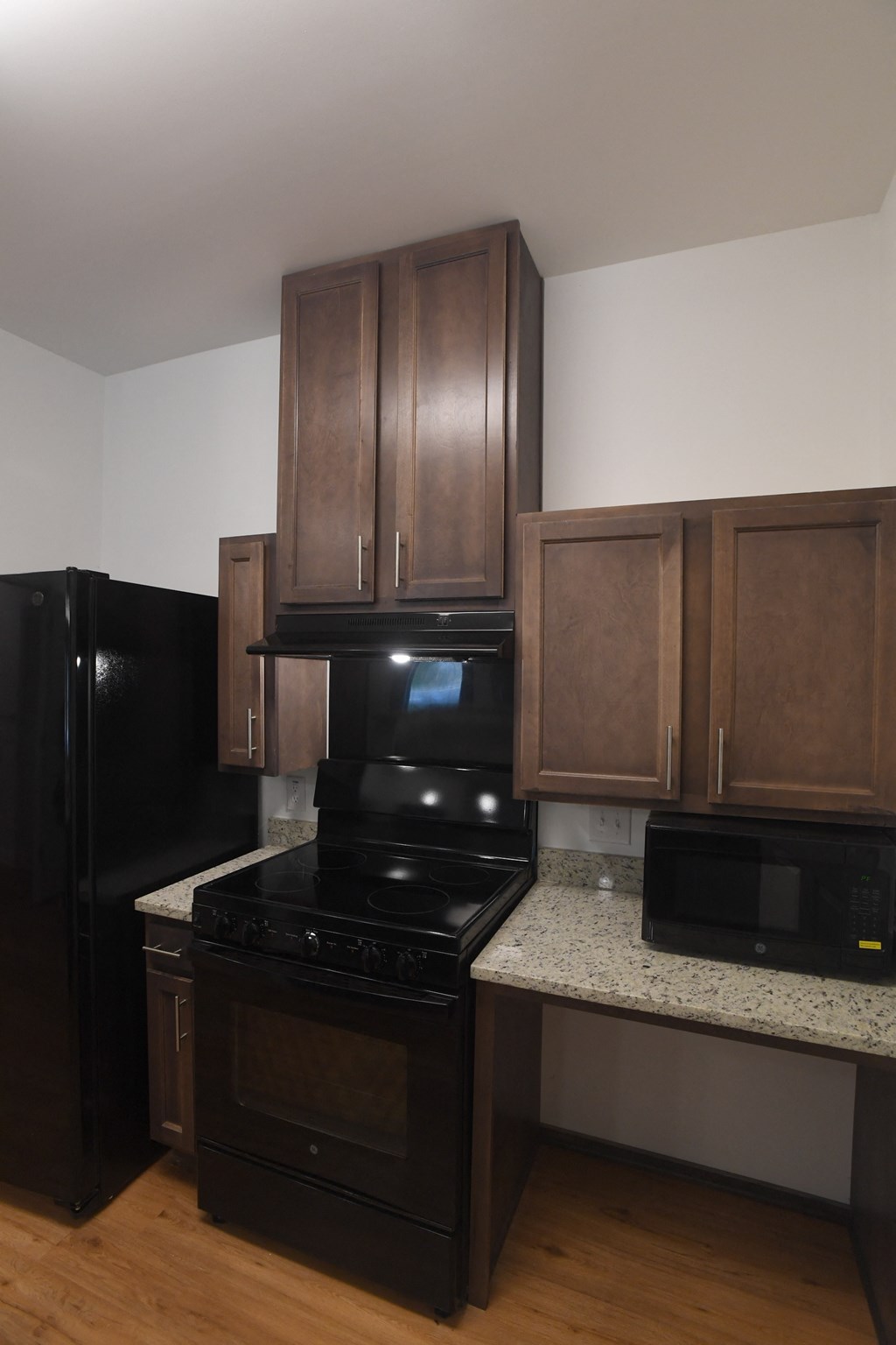 A kitchen with black appliances and wooden cabinets.