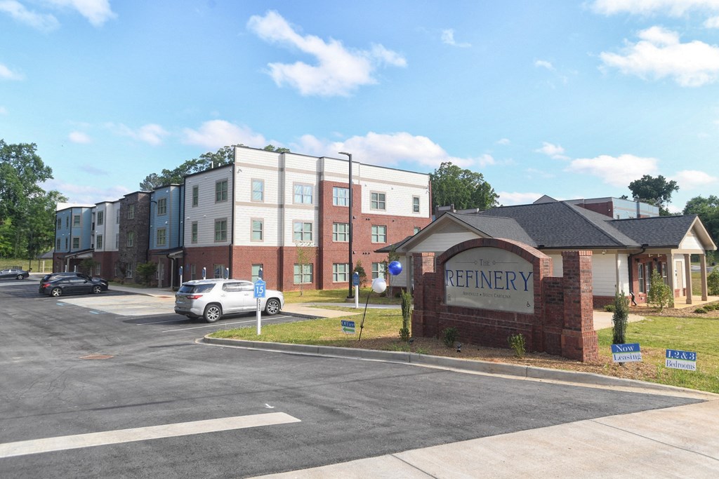 The Refinery is a multi-story building with a parking lot in front.