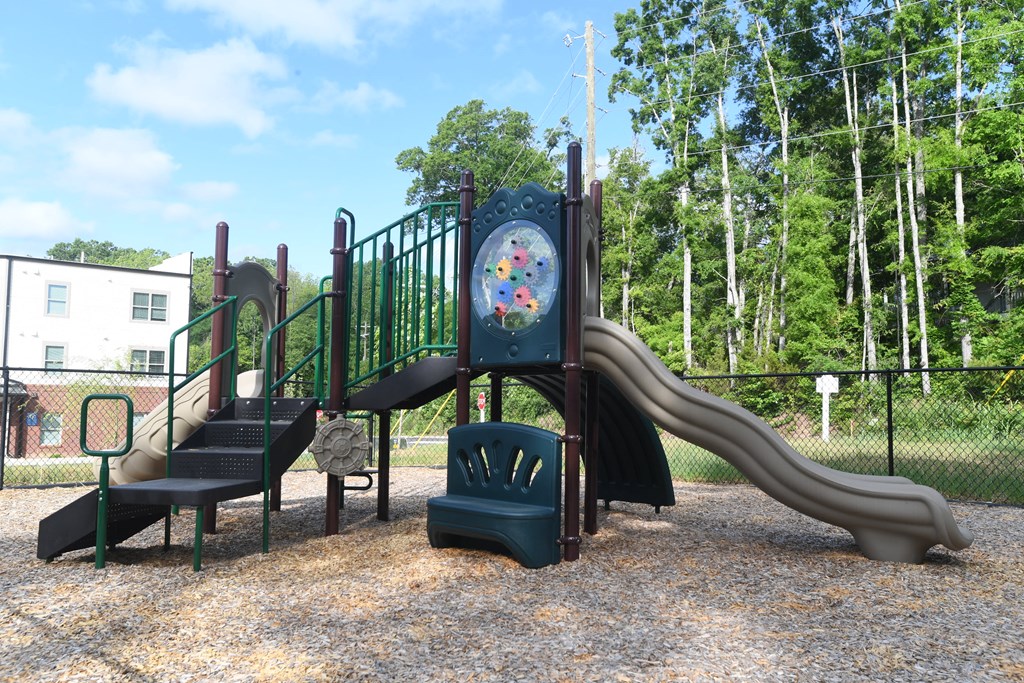 A playground with a slide, swings, and a climbing frame.