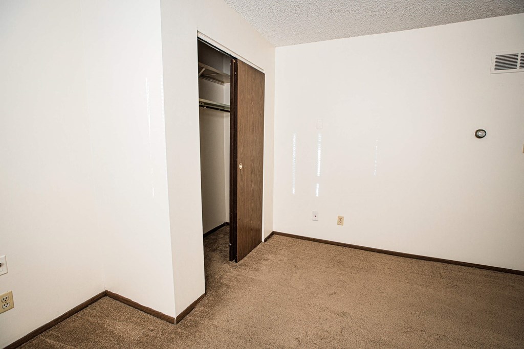 A room with a brown carpet and a brown door.