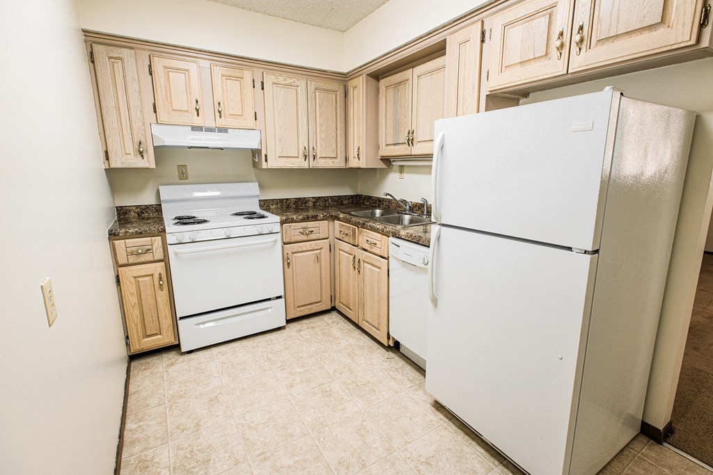 A kitchen with a white refrigerator, white stove, and white oven.