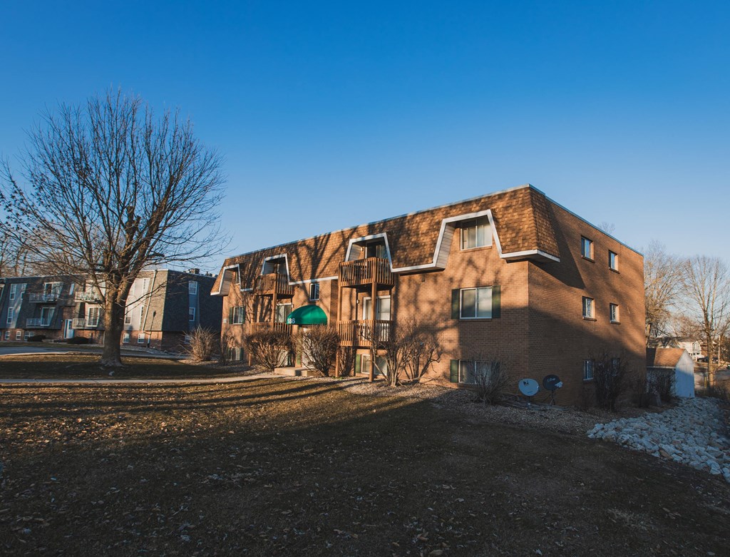 A large brown building with a green awning sits in the foreground of a snowy landscape.
