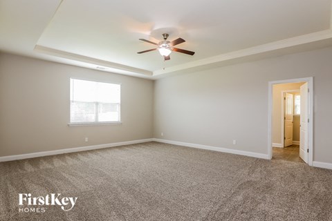 a living room with carpet and a ceiling fan