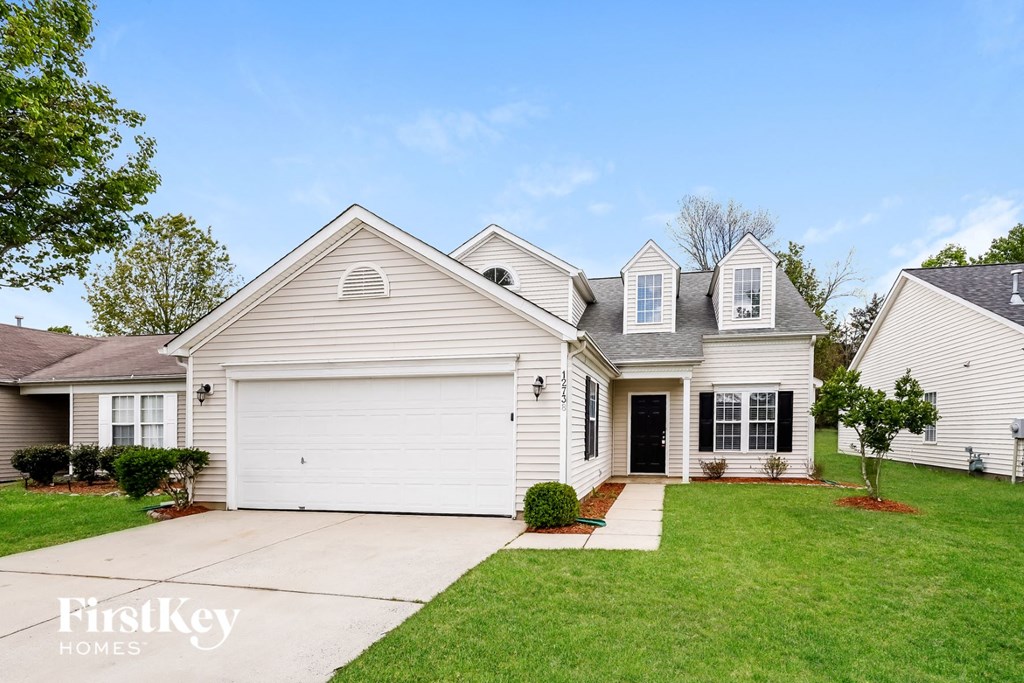 a white house with a white garage door and a green lawn