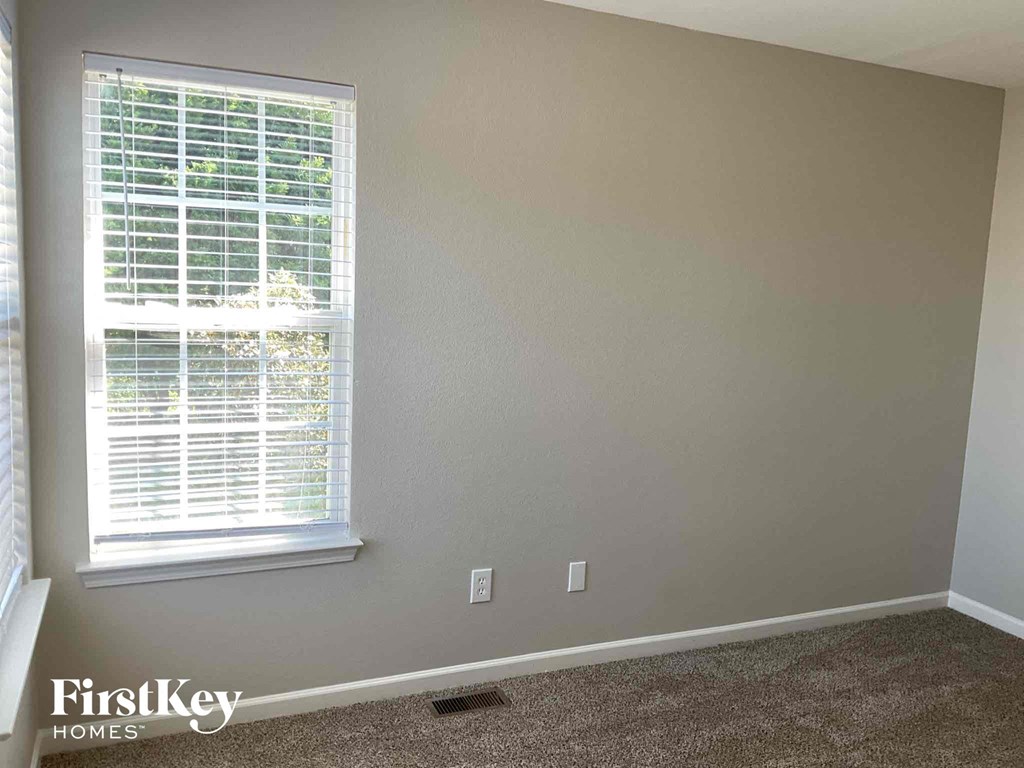 a room with a window and a carpeted floor
