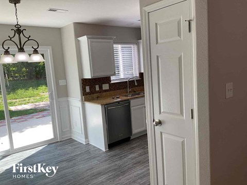 a kitchen with white cabinets and a sink and a window