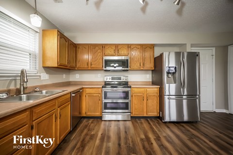 A kitchen with wooden cabinets and a stainless steel refrigerator.