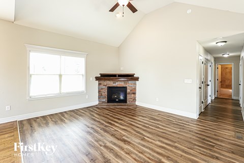 A spacious living room with a fireplace and hardwood floors.