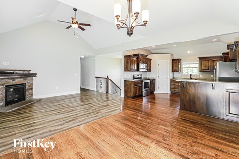 A modern kitchen with wooden floors and a stainless steel refrigerator.