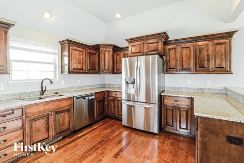 A kitchen with wooden cabinets and a stainless steel refrigerator.