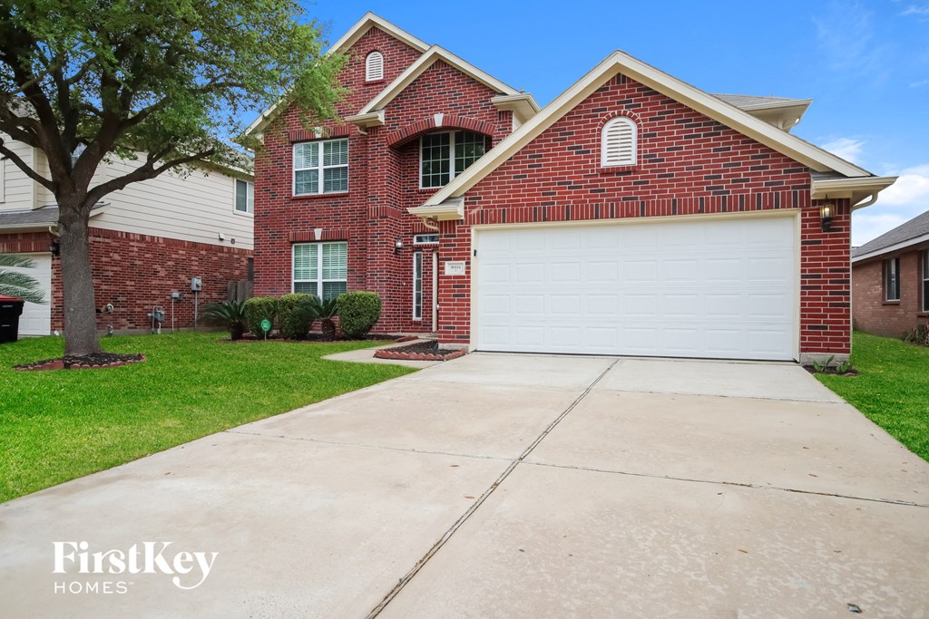 A red brick house with a white garage door.