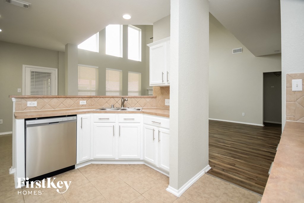 A kitchen with white cabinets and a stainless steel refrigerator.