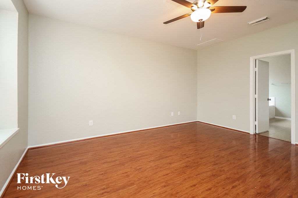 A room with wooden floors and a ceiling fan.