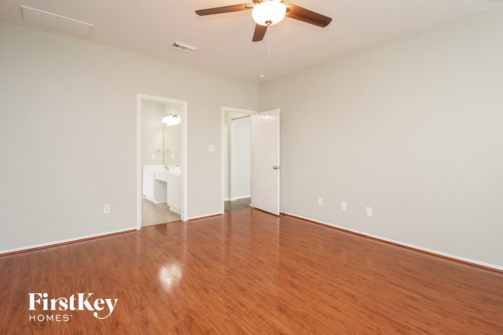 A room with wooden floors and a ceiling fan.