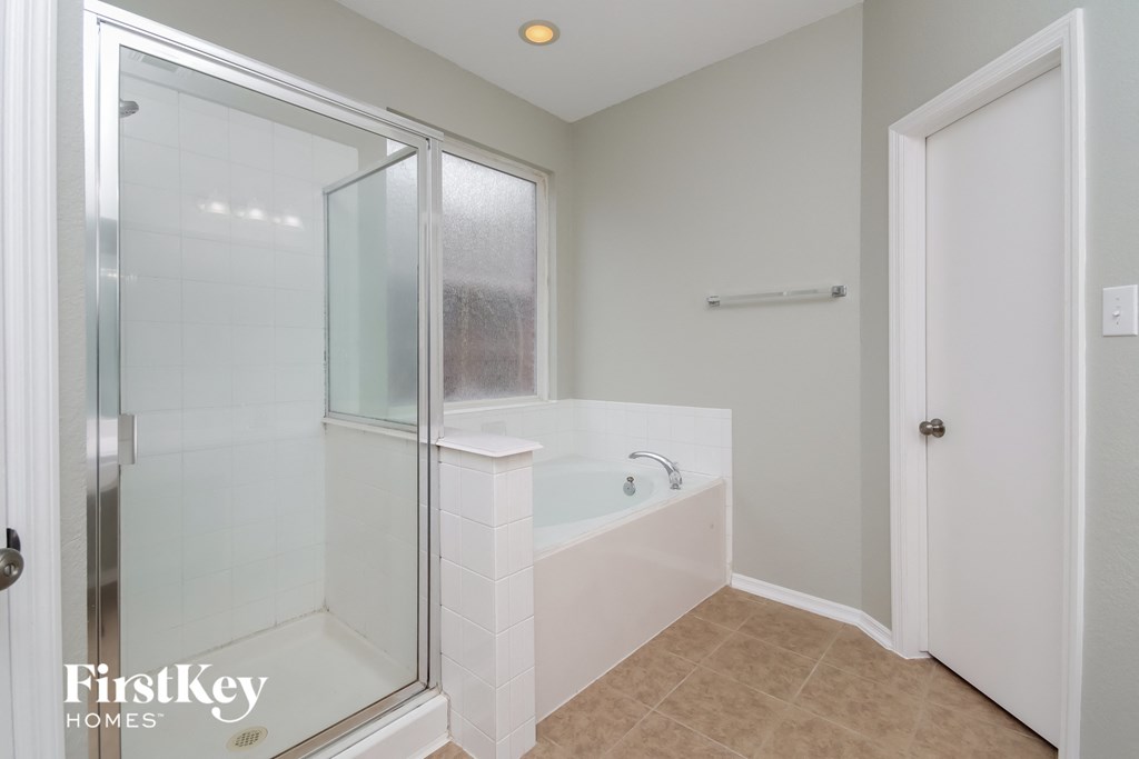 A white bathroom with a walk-in shower and a bathtub.